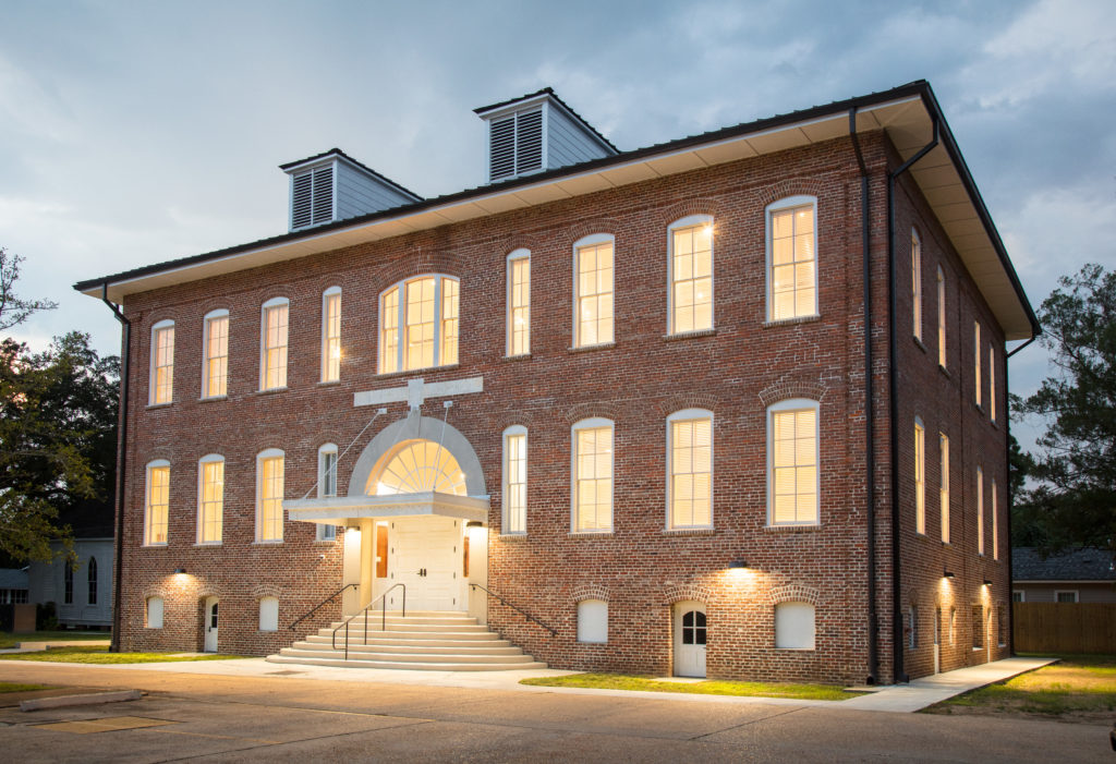 building at dusk with lights on. 2 story building