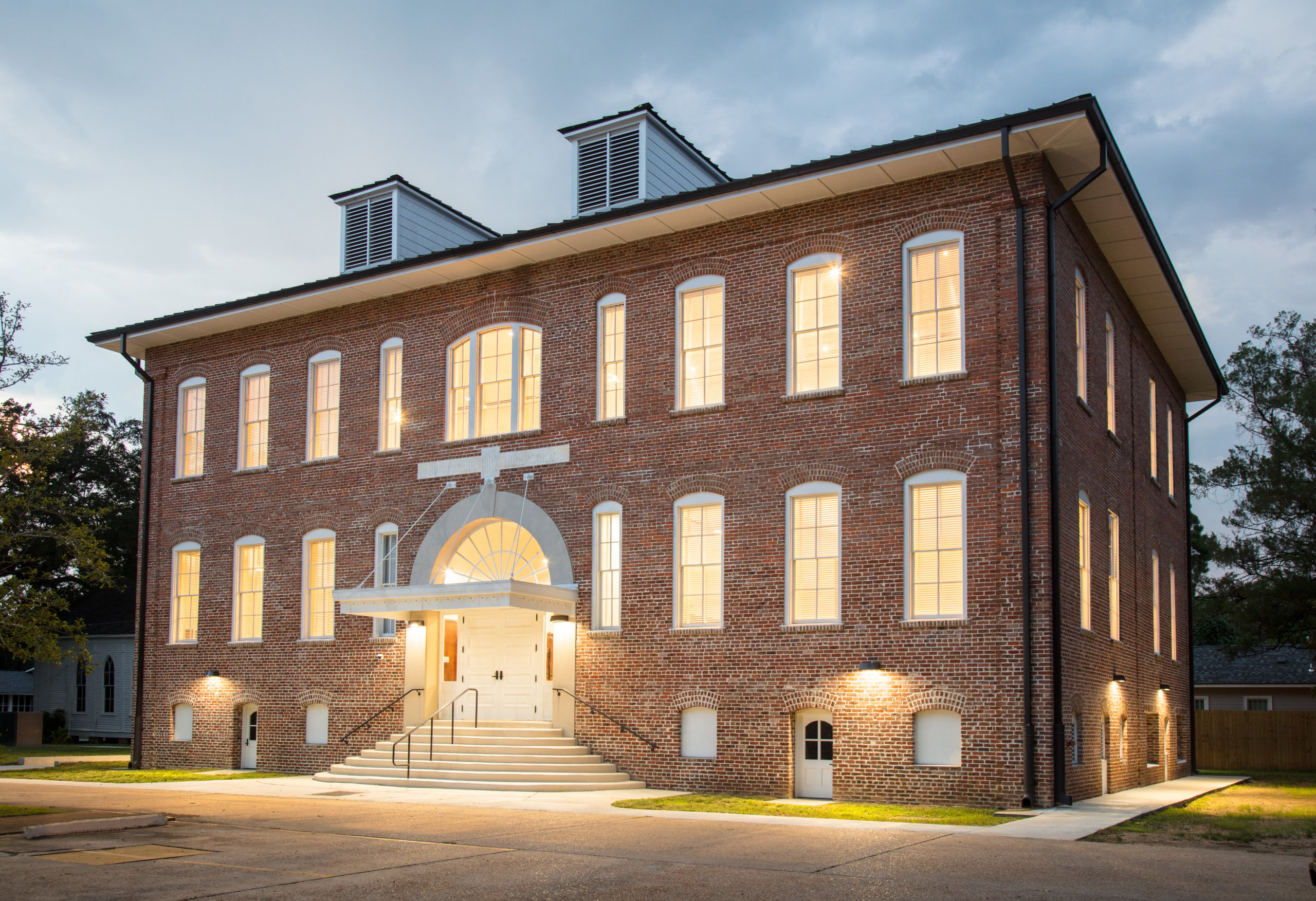 building at dusk with lights on. 2 story building